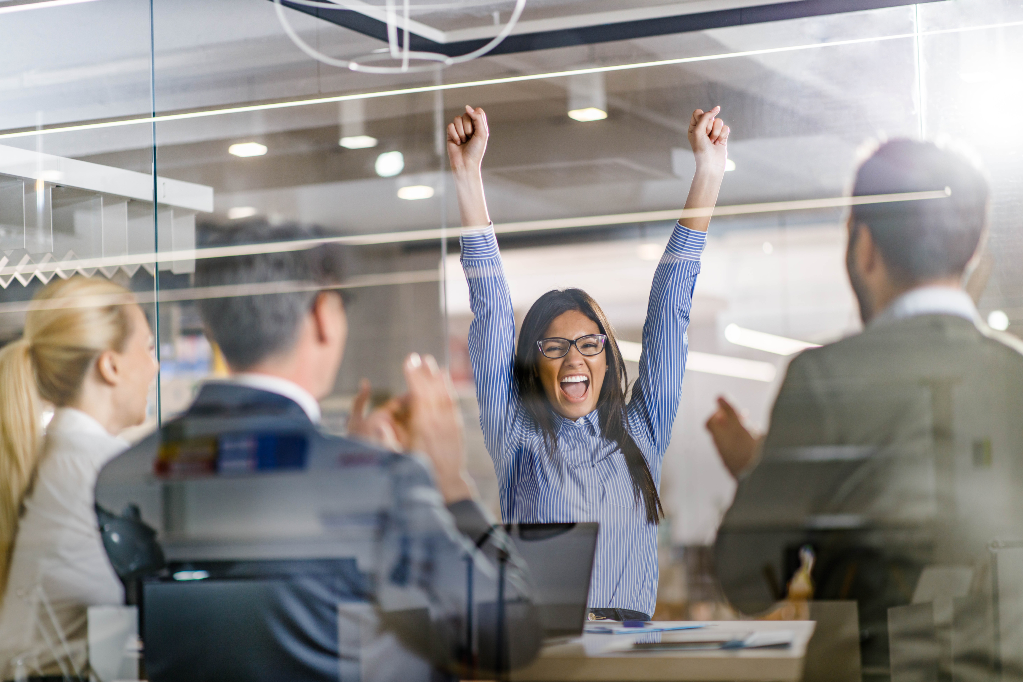 Cheerful female candidate celebrating getting a job on an interview in the office.